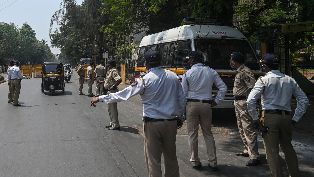 Policemen direct vehicles to stop at a checkpoint during lockdown restrictions imposed in Mumbai. Photo: AFP