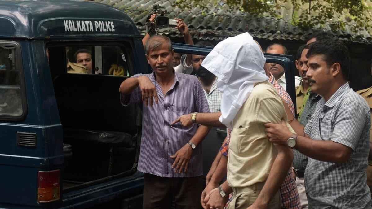 Police officials escort Sanjeev Khanna (face covered), the former husband of Indrani Mukerjea who is accused of murdering of her own daughter Sheena Bora to court in.