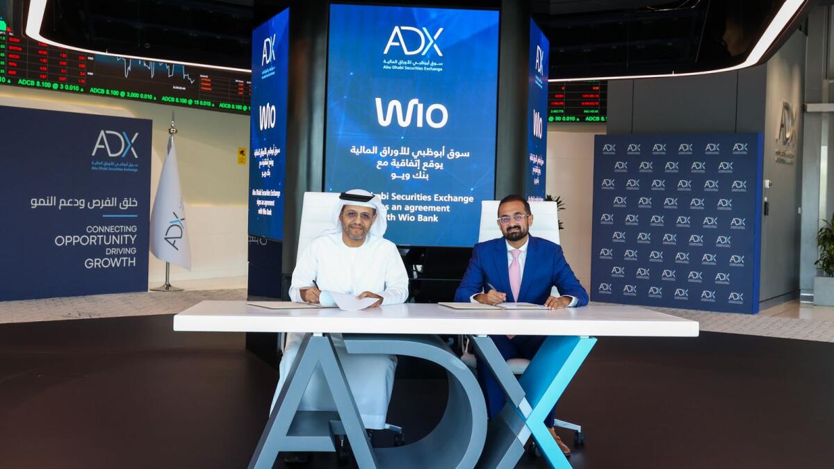 Abdulla Salem Alnuaimi, chief executive officer of ADX and Jayesh Patel, chief executive officer of Wio Bank, sign the agreement. — Supplied photo