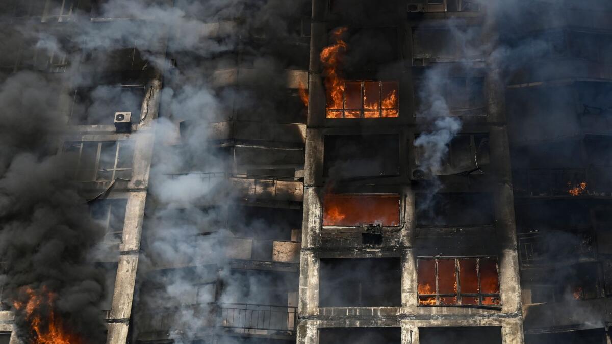 Firefighters extinguish a fire in an apartment building in Kyiv on March 15, 2022, after strikes on residential areas killed at least two people, Ukraine emergency services said as Russian troops intensified their attacks on the Ukrainian capital. Photo: AFP