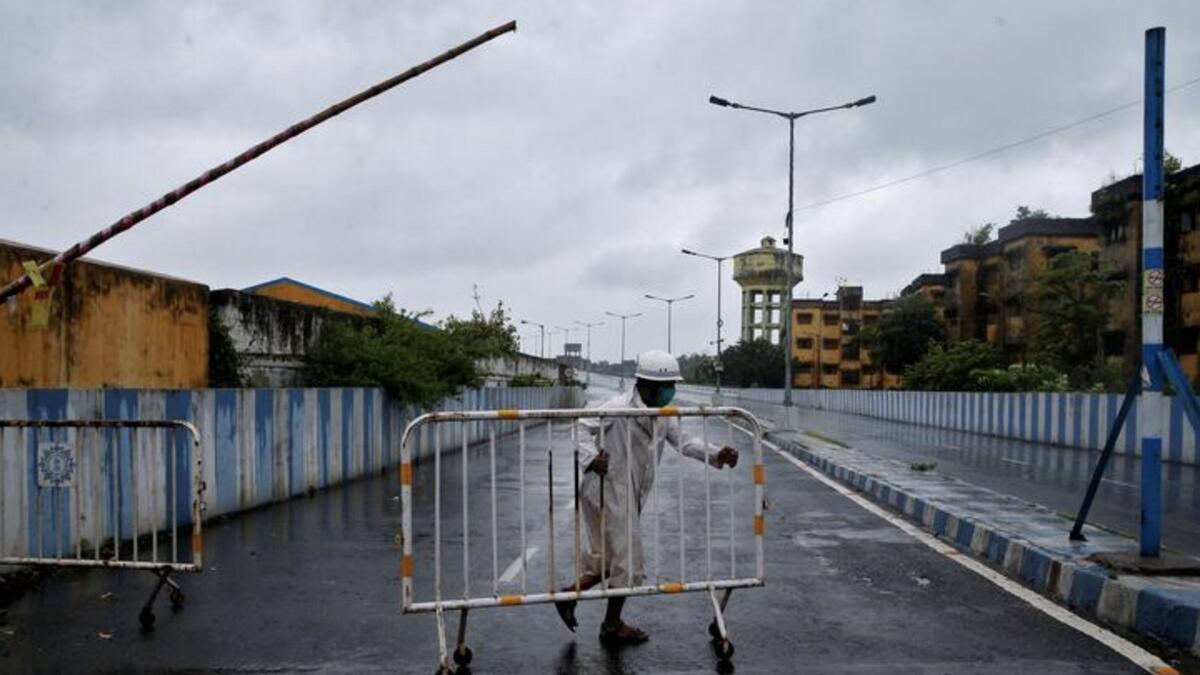 A police officer moves a barricade to block a road leading to a flyover before Cyclone Amphan makes its landfall, in Kolkata, India, May 20. REUTERS/Rupak De Chowdhuri
