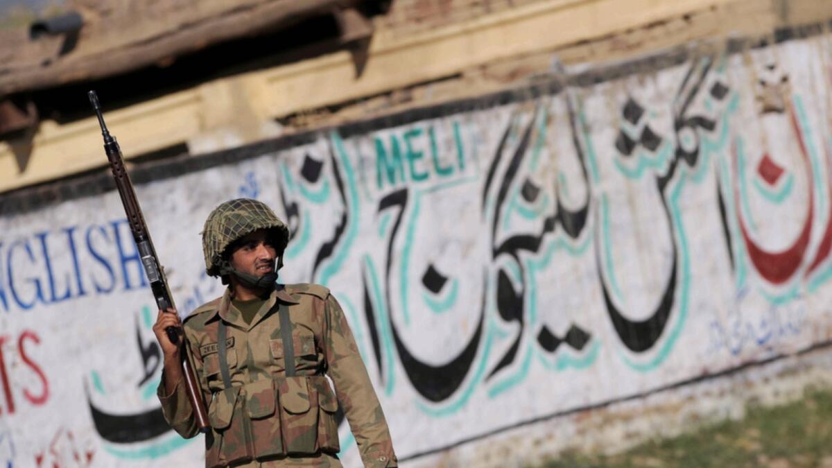 A Pakistani army soldier stands guard in a village in Mardan district, some 200 km northwest of Islamabad. — AFP