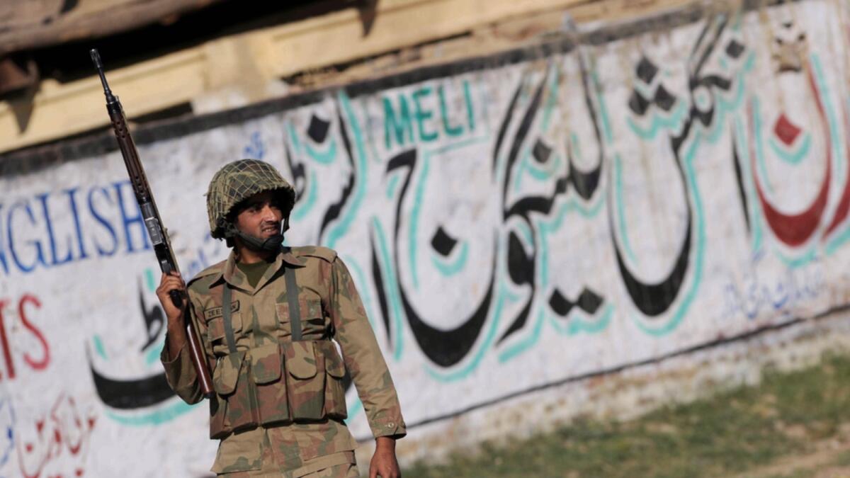 A Pakistani army soldier stands guard in a village in Mardan district, some 200 km northwest of Islamabad. — AFP