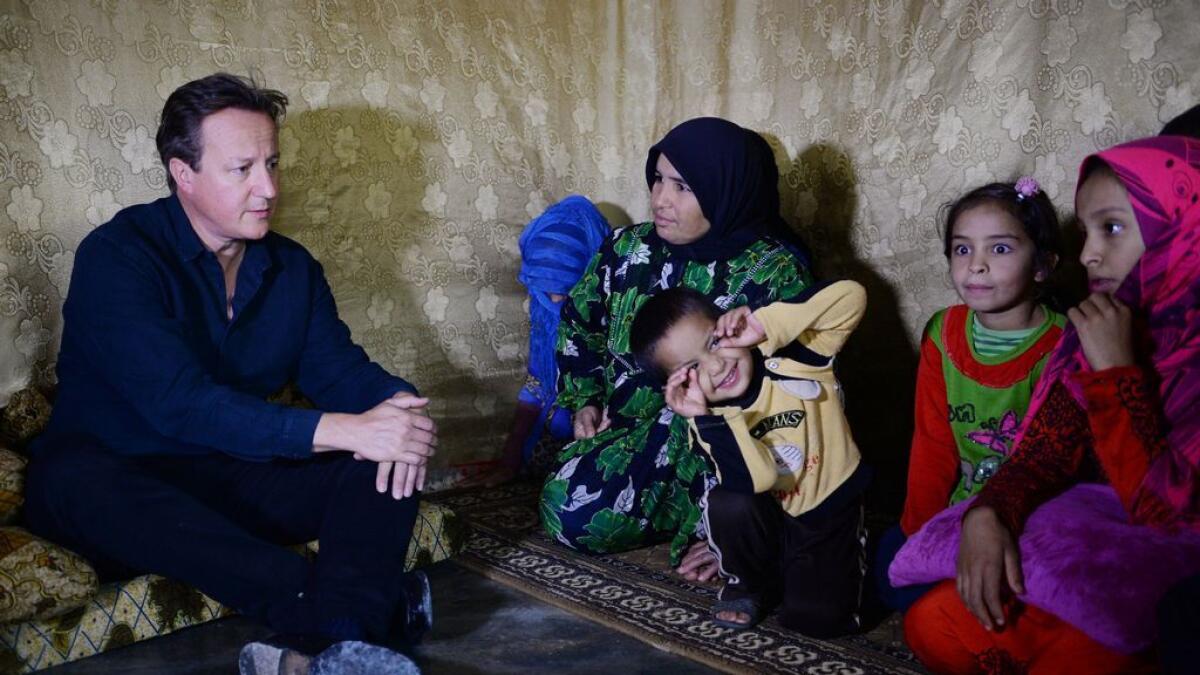 Prime Minister David Cameron meets a Syrian refugee family in a settlement camp in the Bekaa Valley in Lebanon, September 14, 2015. - 