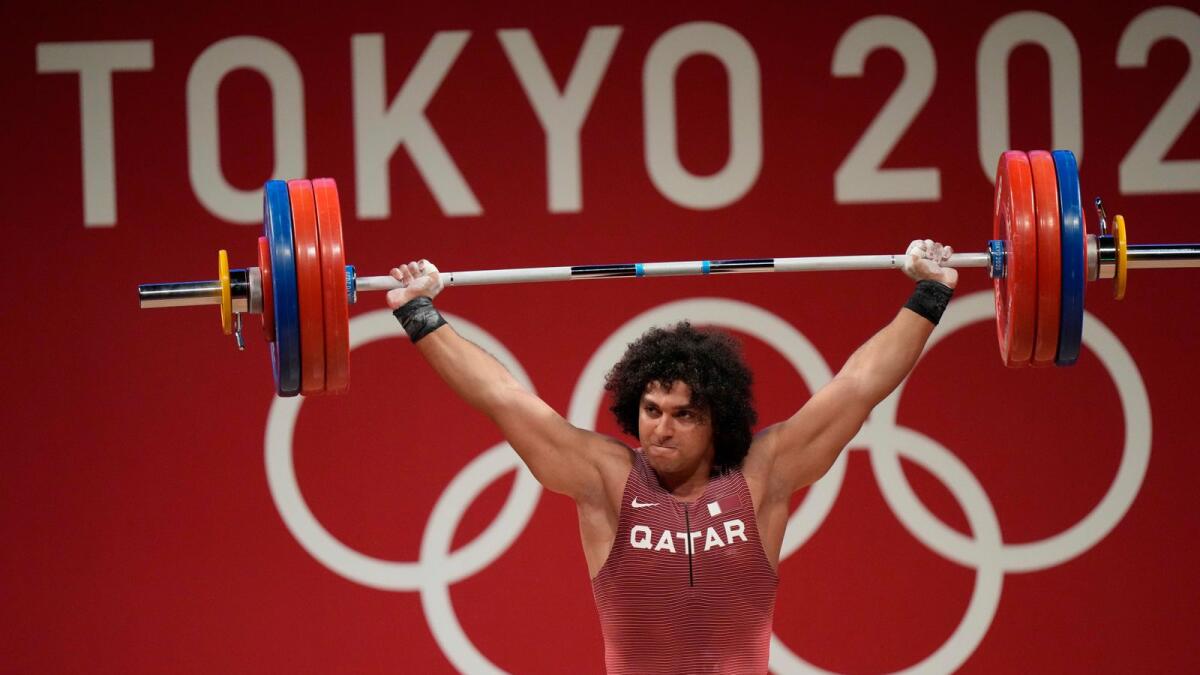 Fares Ibrahim Elbach of Qatar competes in the men's 96kg weightlifting event at the 2020 Summer Olympics on Saturday. — AP