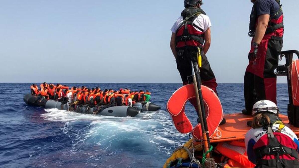 Crew members of the 'Ocean Viking' rescue ship, operated by French NGOs SOS Mediterranee and Medecins sans Frontieres (MSF), stand ready on board of a 'rhib', an inflatable dinghy, as they approach an inflatable boat carrying some 85 migrants on August 9, 2019, during their first rescue operation in the Mediterranean Sea. - For volunteers who come to the rescue of migrants in distress in the Mediterranean Sea, panic in makeshift boats is the enemy that risks taking everything away. In recent years, many deadly accidents off the coast of Libya have occurred as a result of a crowd movement, just as the migrants were seeing help after hours or even days of anguish at sea. (Photo by Anne CHAON / AFP)