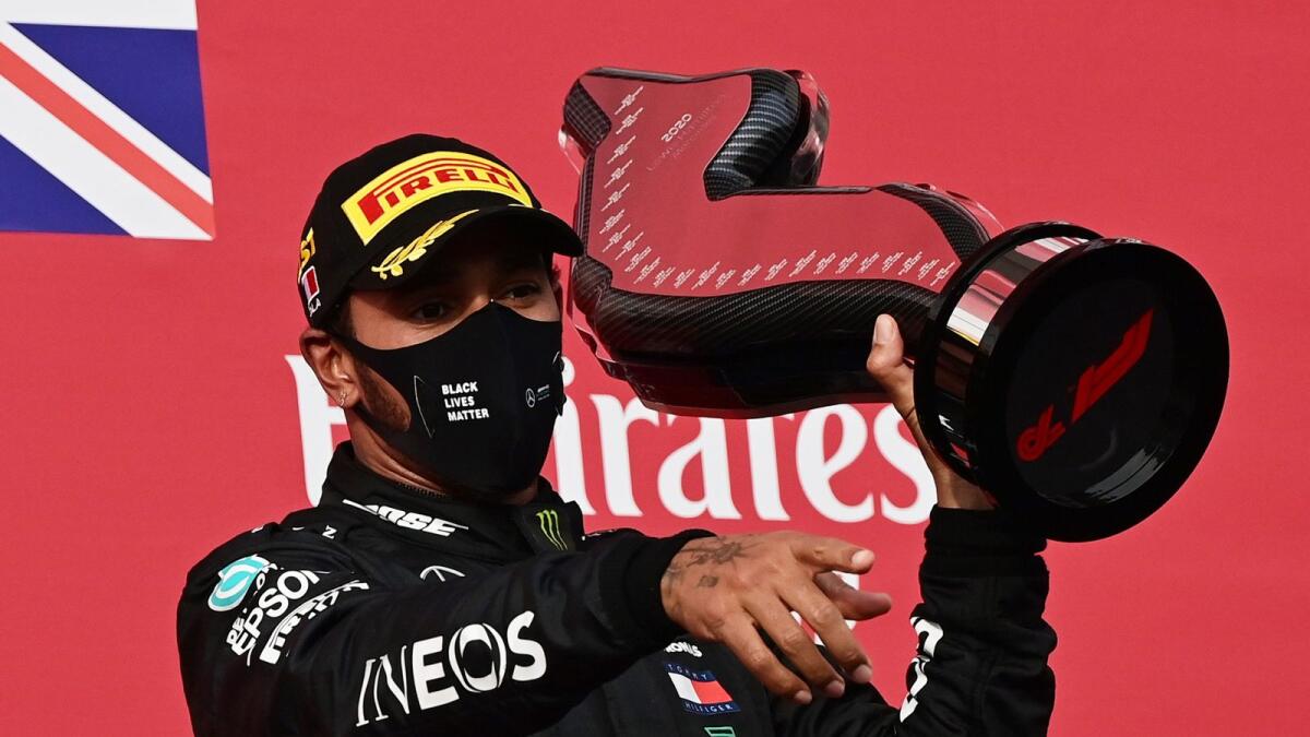 Mercedes' Lewis Hamilton celebrates on the podium with the trophy after winning the race in Imola. — Reuters