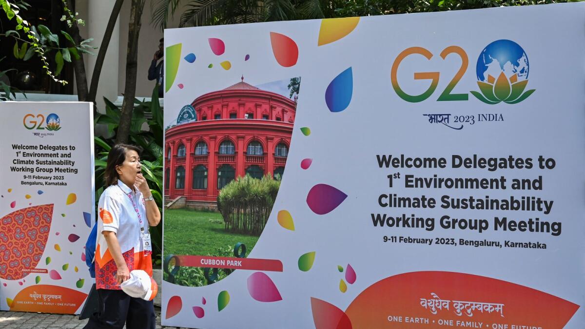 An international delegate walks past a poster of the 1st Environment and Climate Sustainability working group meeting under India’s G20 Presidency in Bengaluru earlier this month. - AFP