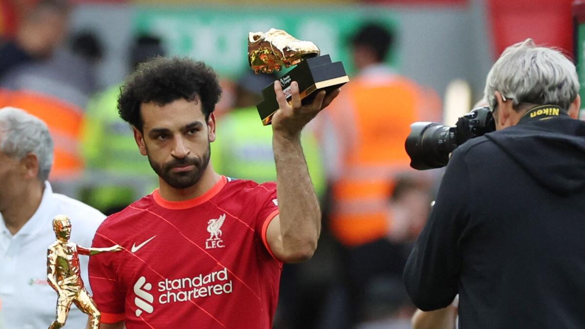 Liverpool's Mohamed Salah holds the Premier League Playmaker and Golden Boot trophies. — Reuters