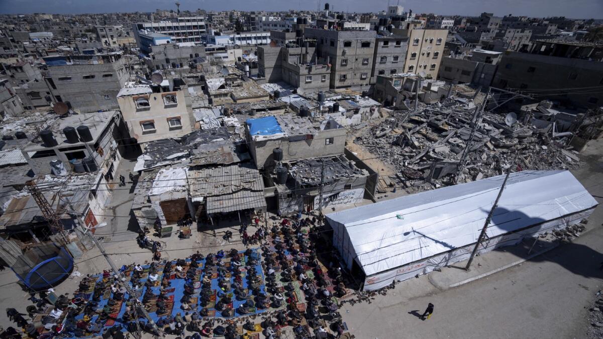 Palestinians perform the first Friday prayers of the holy month of Ramadan near the ruins of a destroyed mosque by the Israeli airstrikes in Rafah. — AP