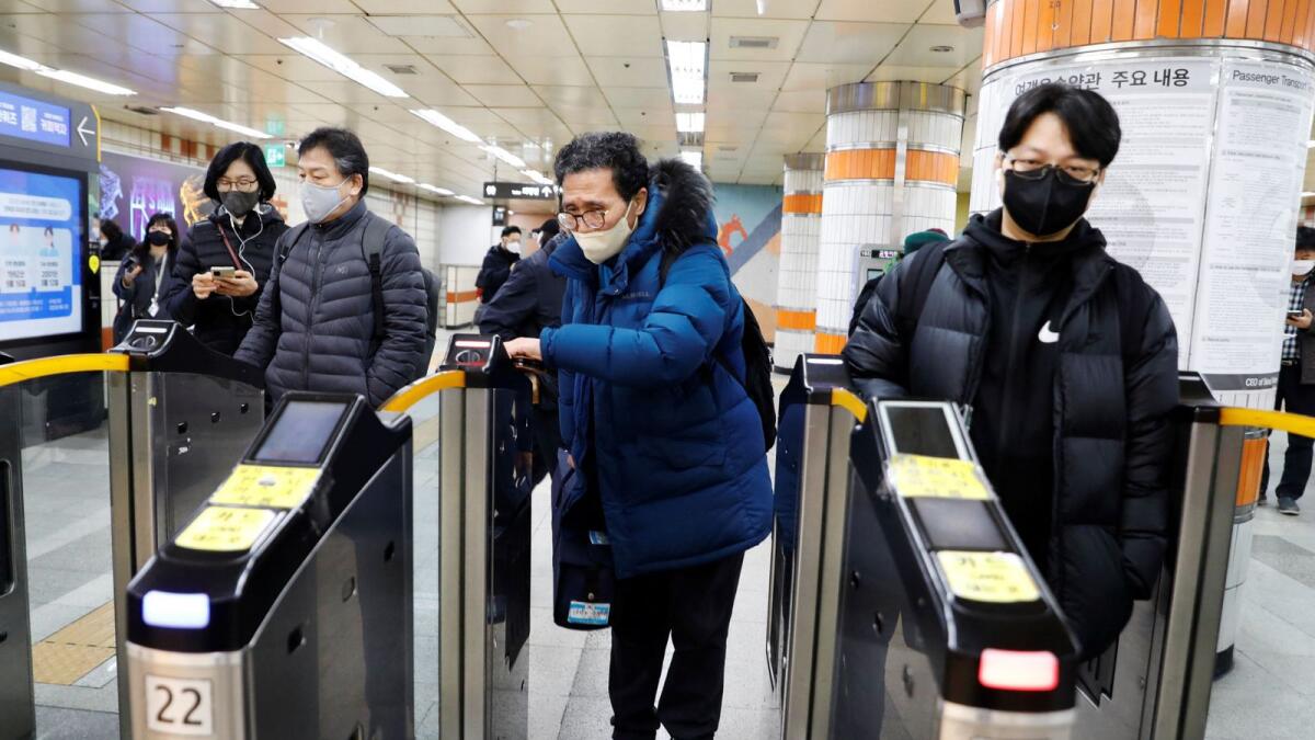 Park Gyung-sun, 71, passes a ticket barrier as he delivers a parcel in Seoul, South Korea. —  Reuters file