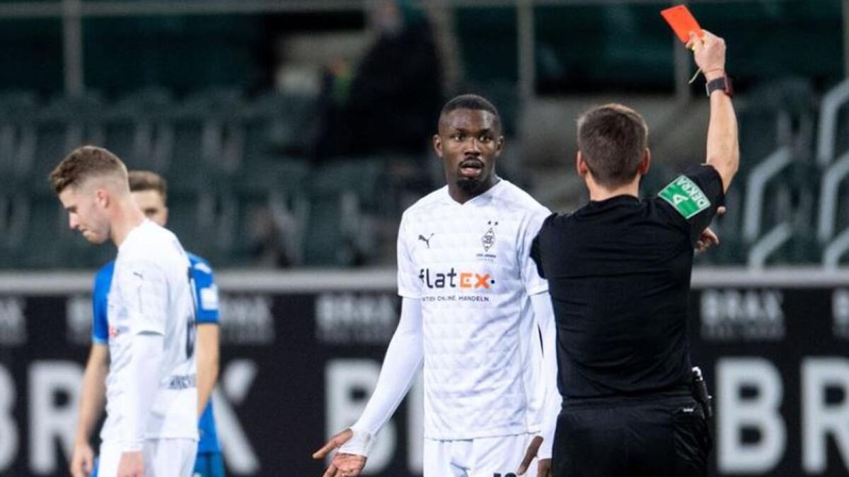 Borussia Moenchengladbach's Marcus Thuram is shown a red card by the referee. (Reuters)