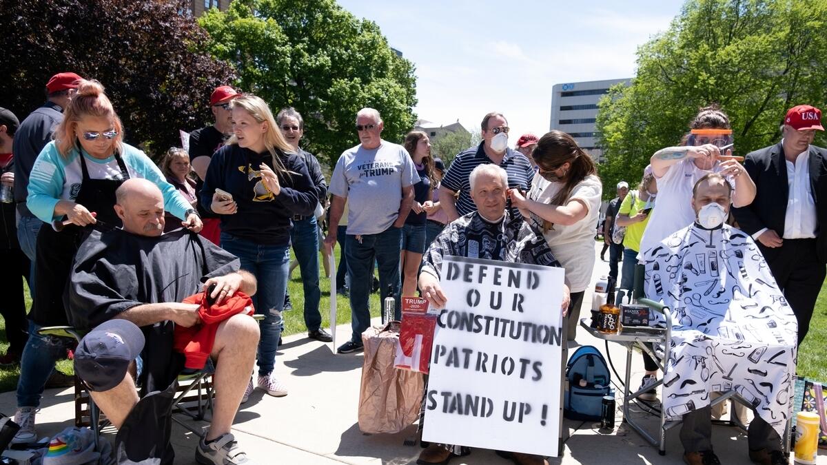 People get their hair cut during 'Operation Haircut', a protest put on by supporters of the Michigan Conservative Coalition at the state capitol, after barber Karl Manke had his licence suspended for violating the coronavirus disease (COVID-19) restrictions, at the Capitol building in Lansing, Michigan, U.S. May 20, 2020.