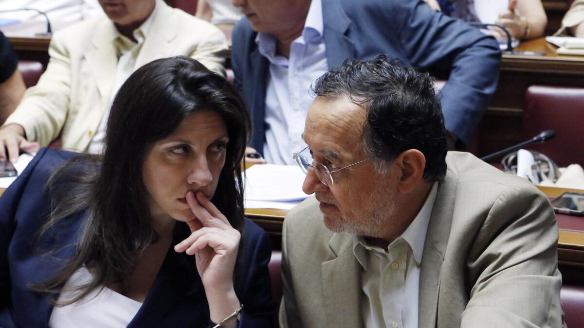 Parliament speaker Zoe Konstantopoulou, left, speaks with Energy Minister Panagiotis Lafazanis during lawmakers meeting of Syriza governing party at the Greek Parliament in Athens, Wednesday, July 15, 2015.