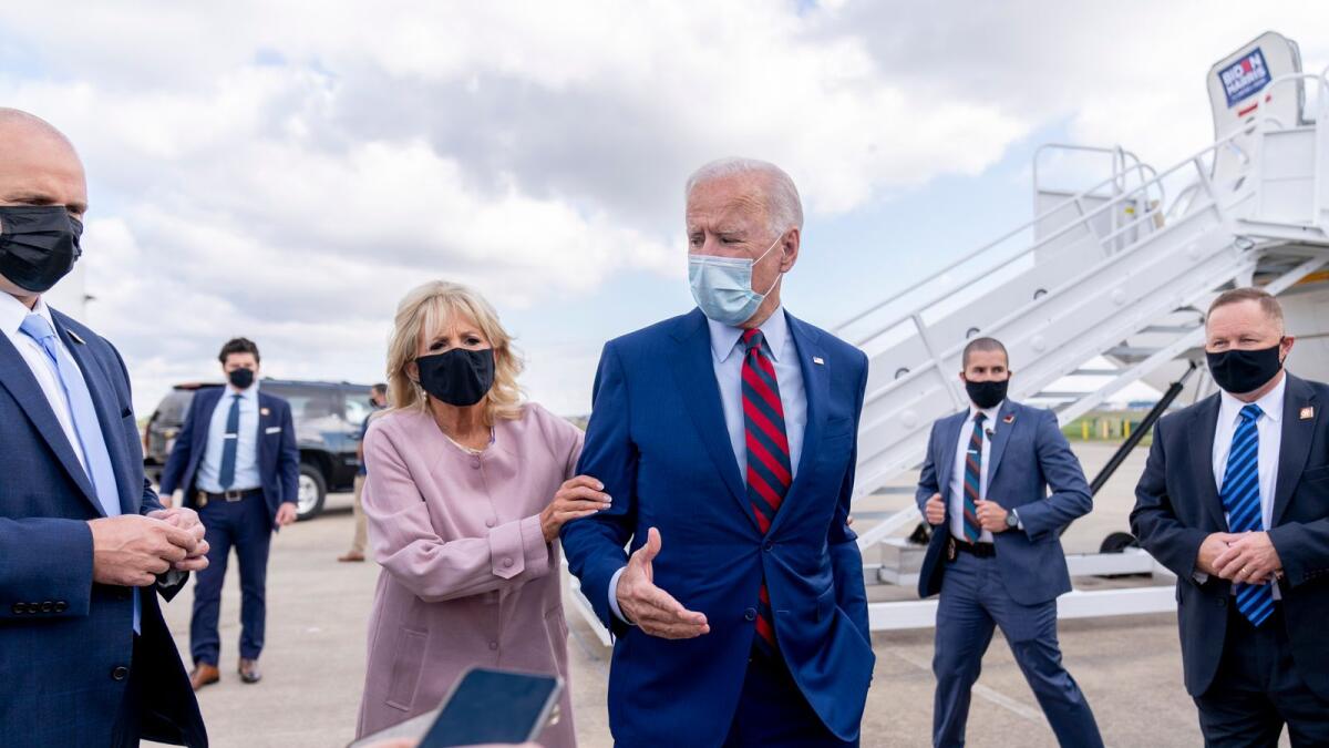 Jill Biden moves her husband back from members of the media as he speaks outside his campaign plane at New Castle Airport in New Castle, Del., to travel to Miami for campaign events.