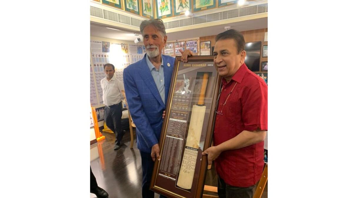 Sunil Gavaskar receives a cricket bat from Shyam Bhatia in Dubai. (Supplied photo)