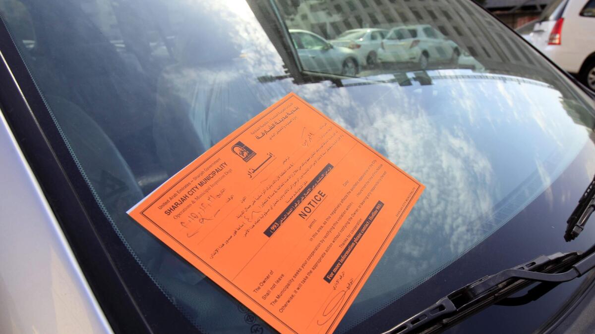 A notice from the municipality is displayed on a used car that is still parked at abu shaghara area on Thursday.