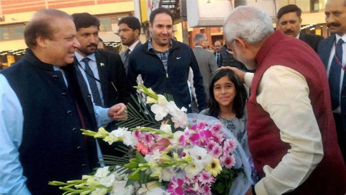Prime Minister Narendra Modi is greeted by a girl as his Pakistani counterpart Nawaz Sharif looks on upon his arrival in Lahore.