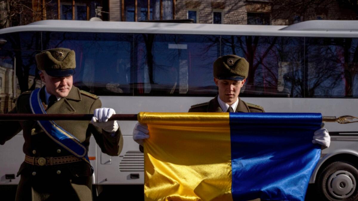 Honor guard soldiers fold an Ukraine flag following a ceremony to mark the anniversary of the withdrawal of Soviet troops from Afghanistan, in Kyiv. — AP