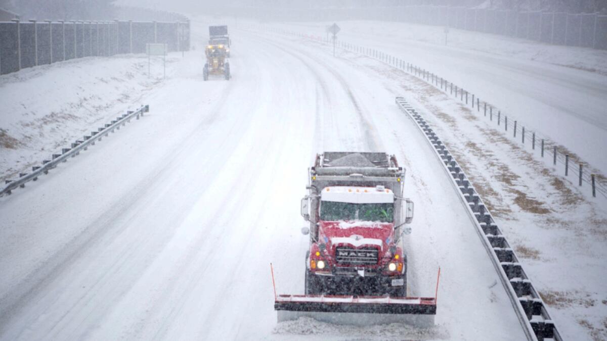 Plows work on Interstate 581 at the Liberty Road NW overpass during the snow storm in Roanoke, Va. — AP