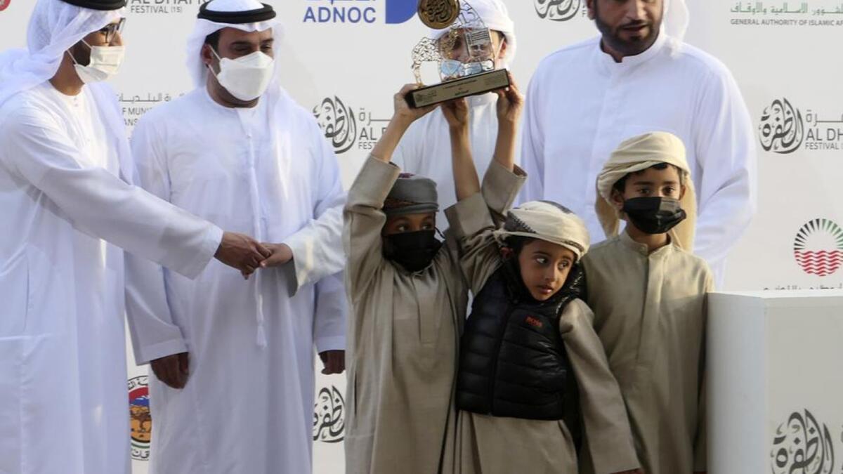 Victorious camel breeders accept a trophy for their camel at Al Dhafra Festival . — AP