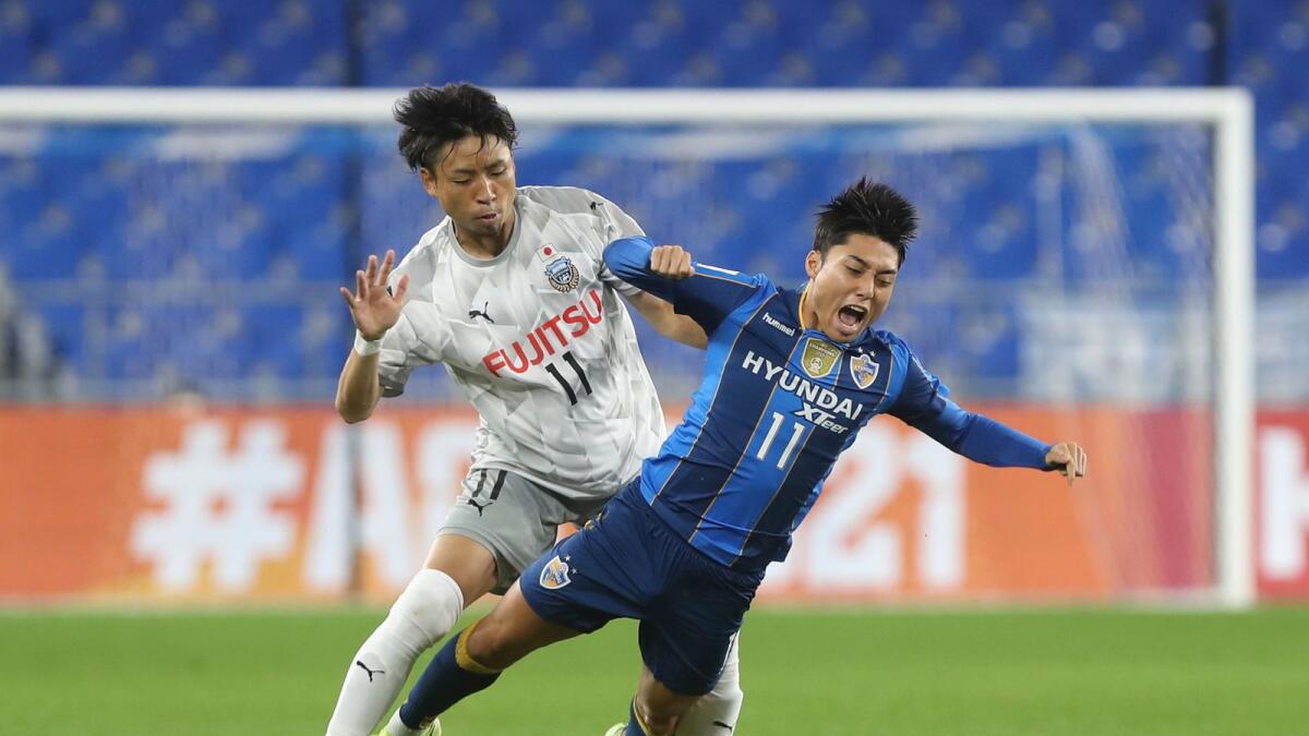 Japanese Kawasaki Frontale’ Yu Kobayashi (left) fights for the ball against South Korean Ulsan Hyundai FC’ Lee Dong-jun during the AFC Champions League match. — AP