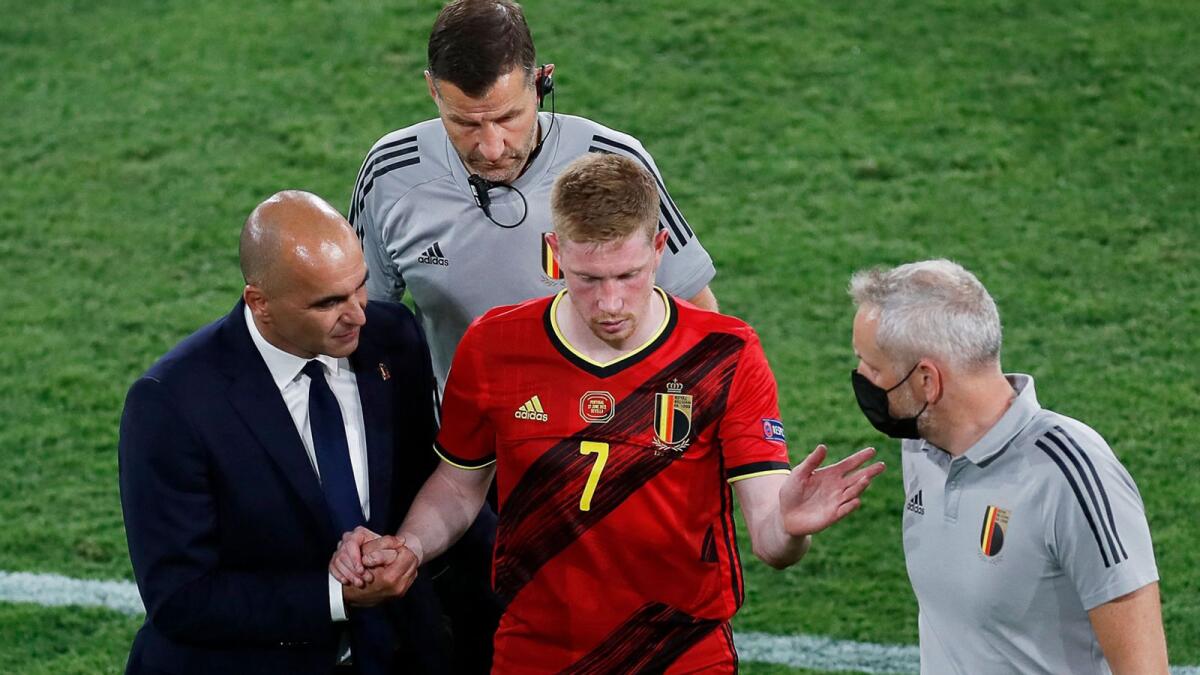Belgium's Spanish coach Roberto Martinez (left) speaks to Belgium's midfielder Kevin De Bruyne (centre) after being taken off following an injury during the Euro 2020 round of 16 match against Portugal.— AFP