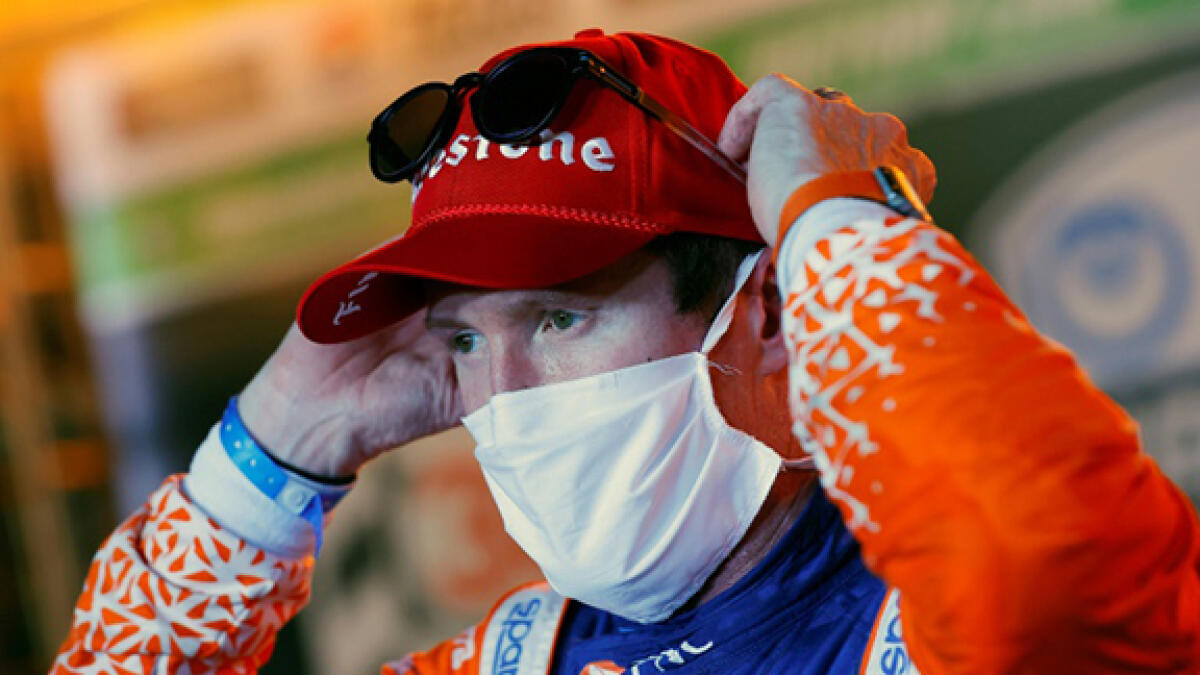 Scott Dixon adjusts his protective mask in victory lane after grabbing the checkered flag in the first IndyCar race in eight months due to the Covid-19 pandemic. -- AFP