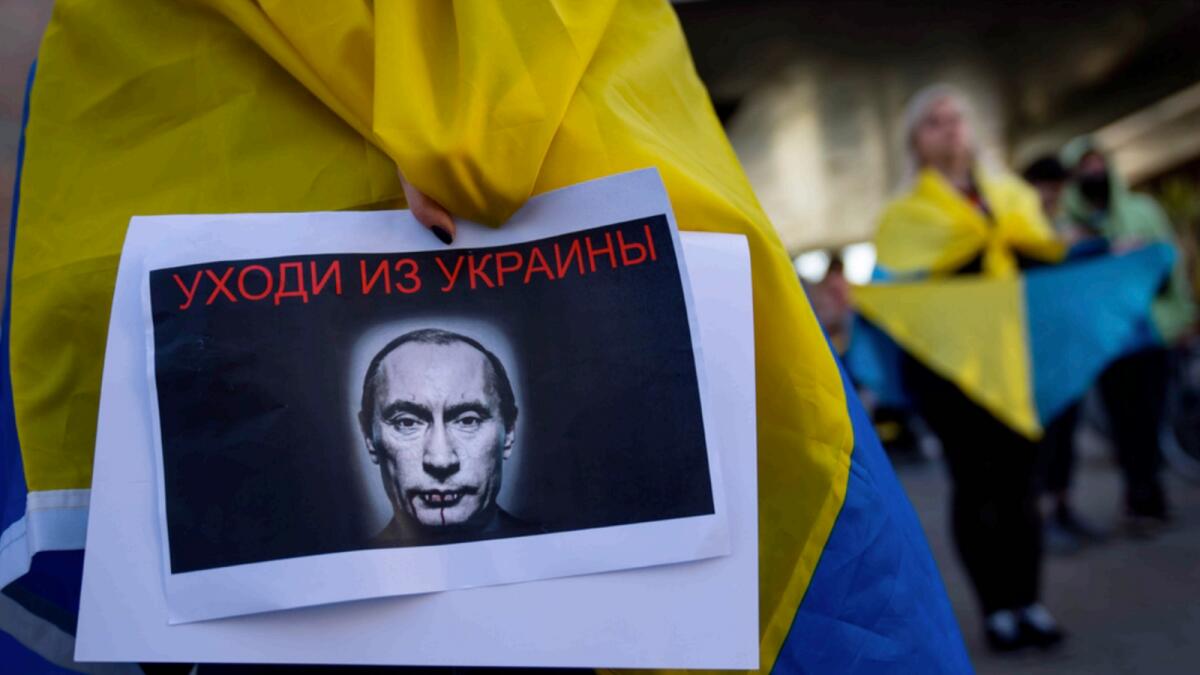 A demonstrator holds a banner depicting Russian President Vladimir Putin during a pro-Ukraine protest outside the Russian Embassy in Tel Aviv. — AP