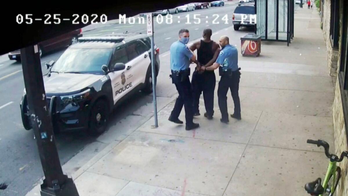 This image from video shows Minneapolis Police Officers Thomas Lane, left and J. Alexander Kueng, right, escorting George Floyd, center, to a police vehicle outside Cup Foods in Minneapolis, on May 25, 2020. — AP file