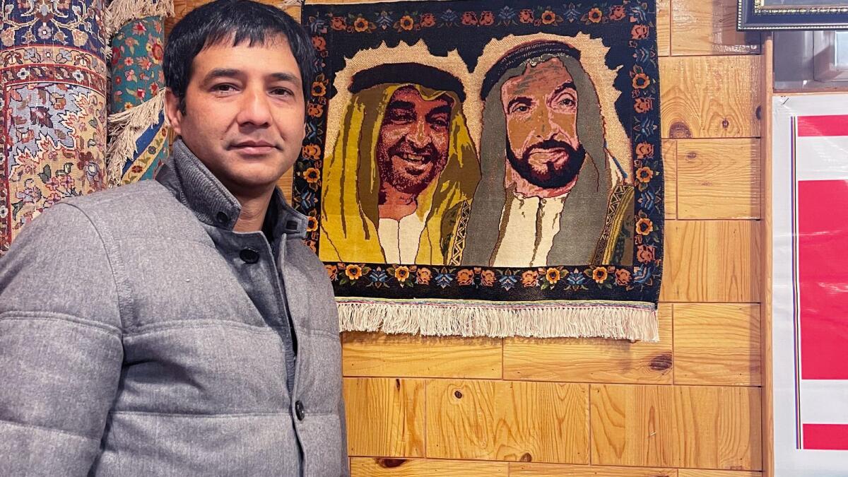 Shahnawaz with his carpet depicting UAE rulers