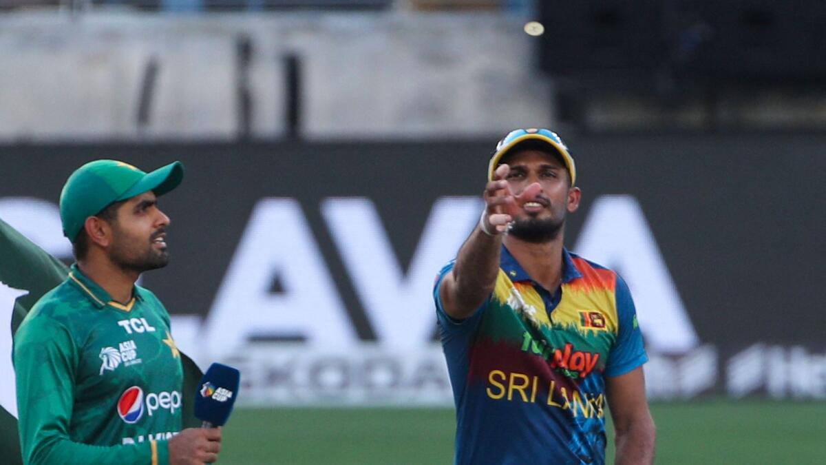 Sri Lankan captain Dasun Shanaka (right) tosses the coin as Pakistan skipper Babar Azam looks on. — AFP