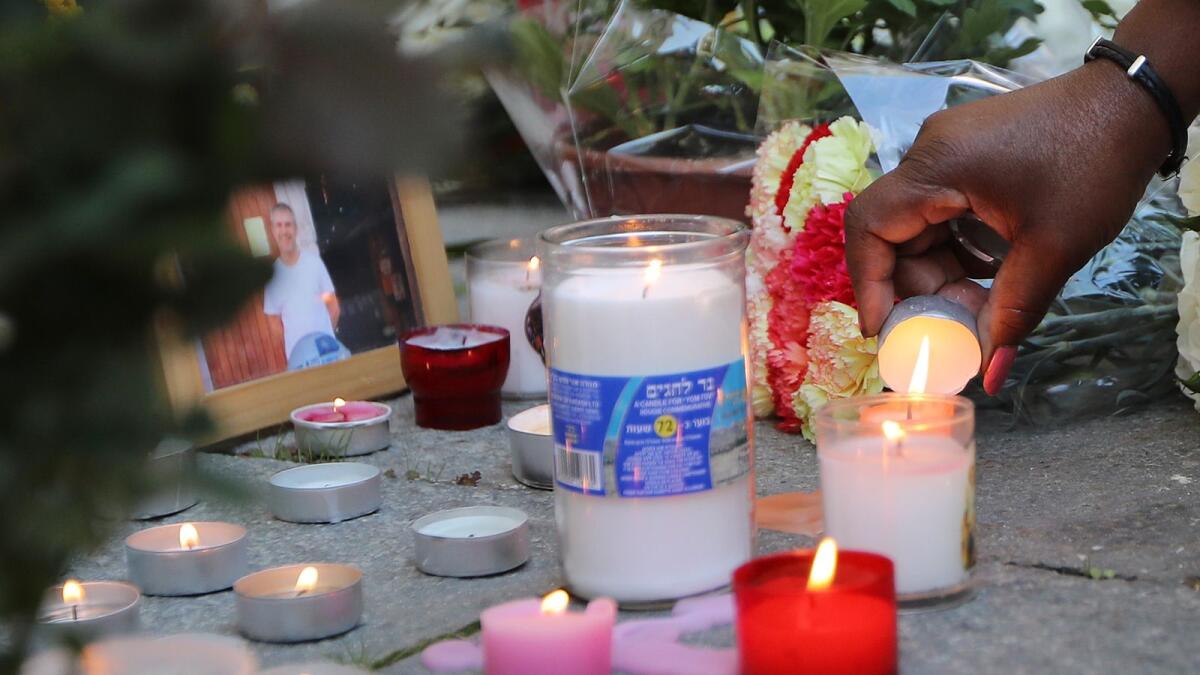 A woman lights a candle near the picture of Vincent Loques, one of the victim killed by a knife attacker the day before, at Notre-Dame de l'Assomption Basilica in Nice on October 30, 2020.