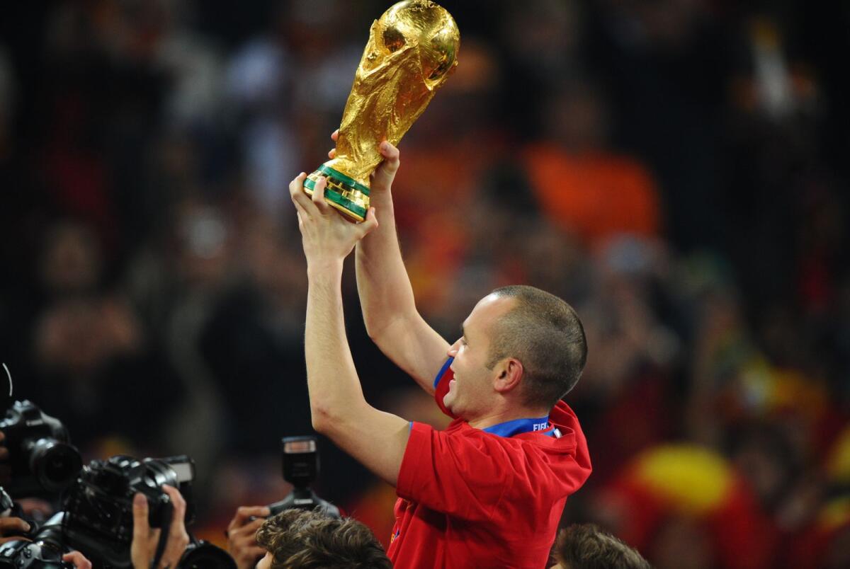Andrés Iniesta celebrates with the trophy after his goal helped Spain beat the Netherlands in the 2010 World Cup final. — AFP file