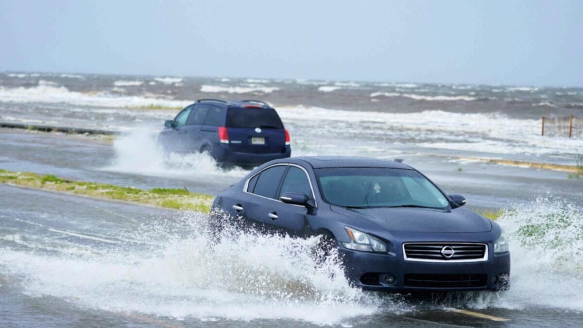 Cars drive through flood waters along route 90 as outer bands of Hurricane Ida arrive in Gulfport. — AP