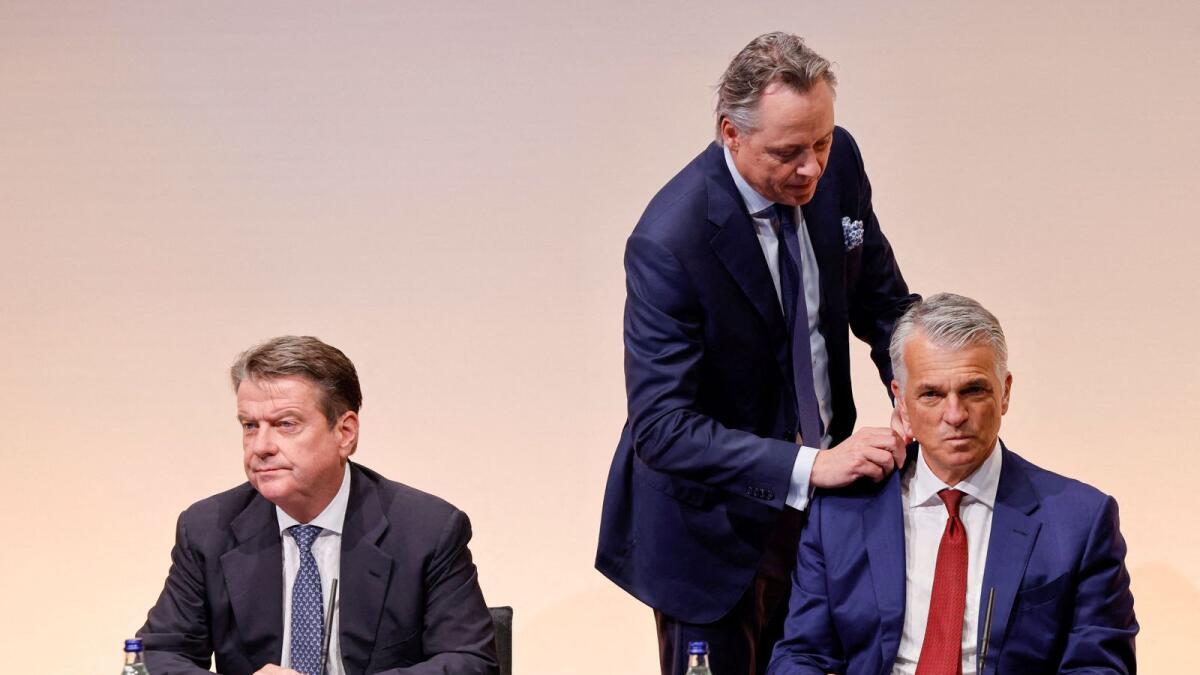 Former CEO and newly appointed advisor Ralph Hamers, adjusts the jacket of Sergio Ermotti, newly rehired CEO of UBS Group AG, while sitting next to UBS Chairman Colm Kelleher, before a news conference in Zurich on Wednesday. - Reuters