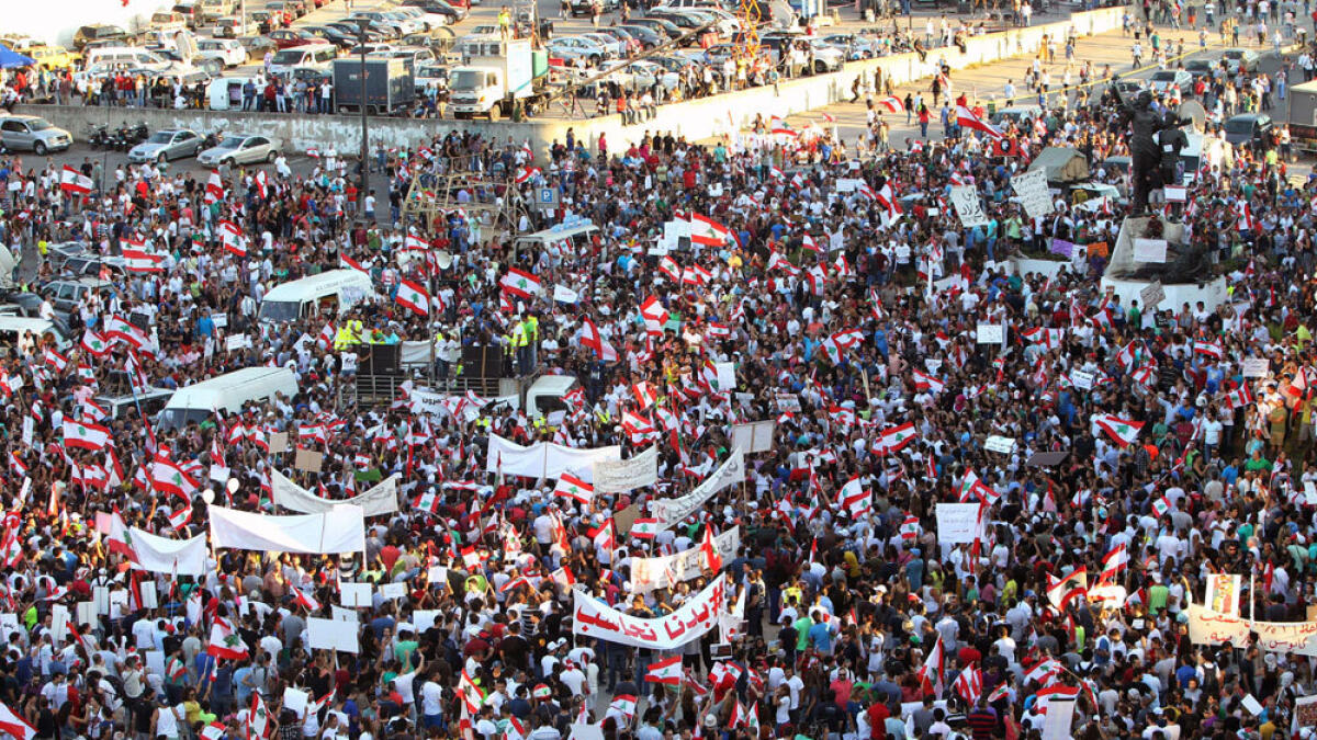Lebanese hold banners and flags during a mass rally against a political class seen as corrupt and incapable of providing basic services in Beirut.