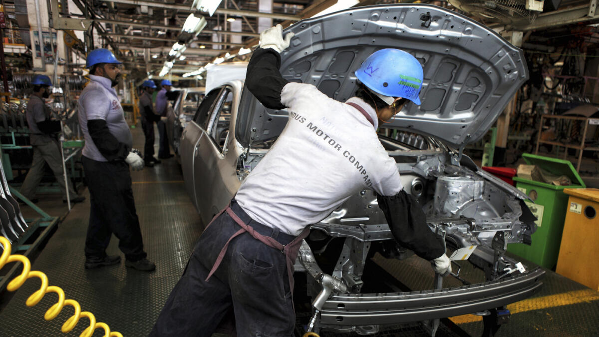 Employees of Indus Motors work on a Toyota Corolla assembly line in the company’s plant in Karachi. 