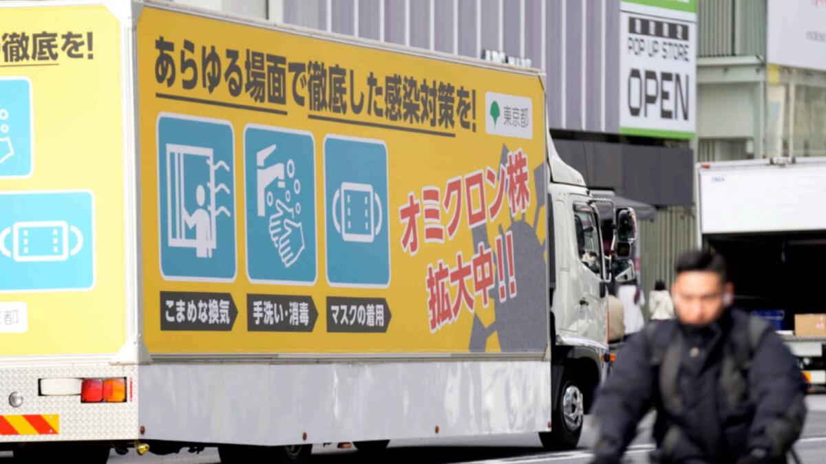 A truck with a public awareness notice on the Omicron variant moves though a busy shopping street in Tokyo. — AP