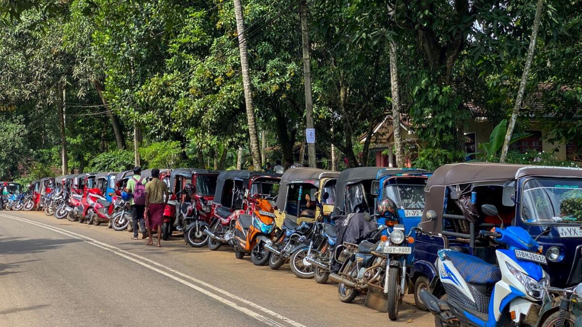 Motorists queue along a street to buy fuel at a fuel station in Pugoda. –AFP