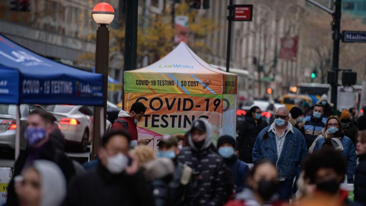 People walk past a covid-19 testing booth on a street in New York city on December 21, 2021.(Photo: AFP)