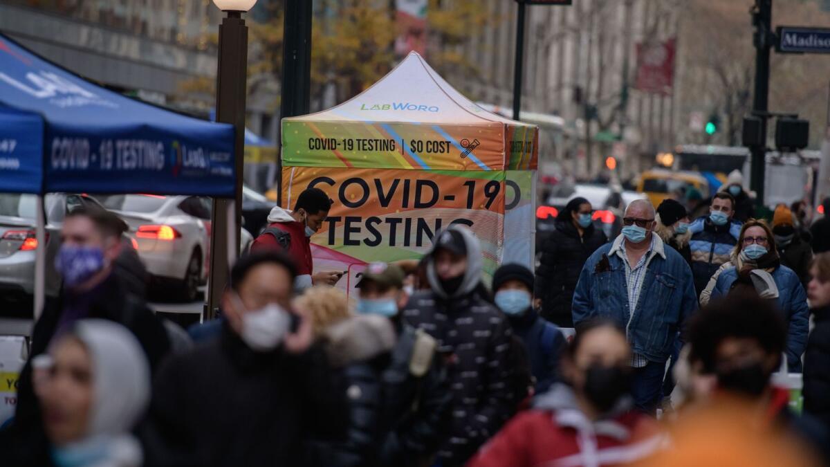 People walk past a covid-19 testing booth on a street in New York city on December 21, 2021.(Photo: AFP)
