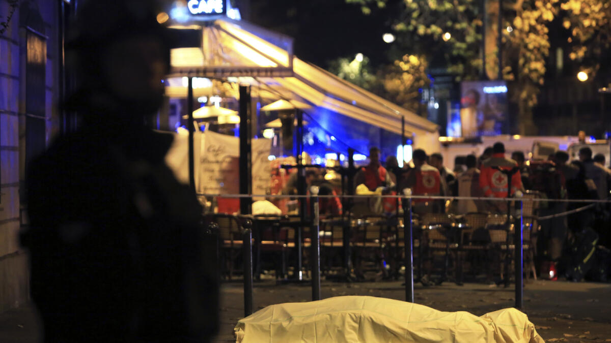 A lifeless body covered under sheet lies on the pavement near the Bataclan theater after a shooting in Paris, Friday Nov. 13, 2015. AP photo