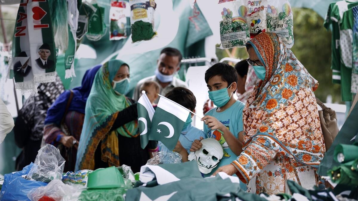 People shop Pakistani national flags, badges and masks and other stuff at a market ahead of Independence Day celebrations, in Islamabad. AP photo