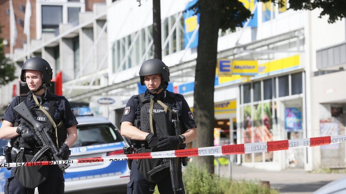 Police officers secure the area after a knife attack at a supermarket in Hamburg, Germany
