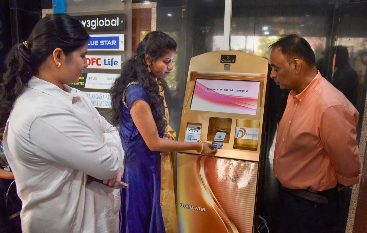 A woman withdraws gold coins from India's first Gold ATM in Hyderabad on Monday. — PTI