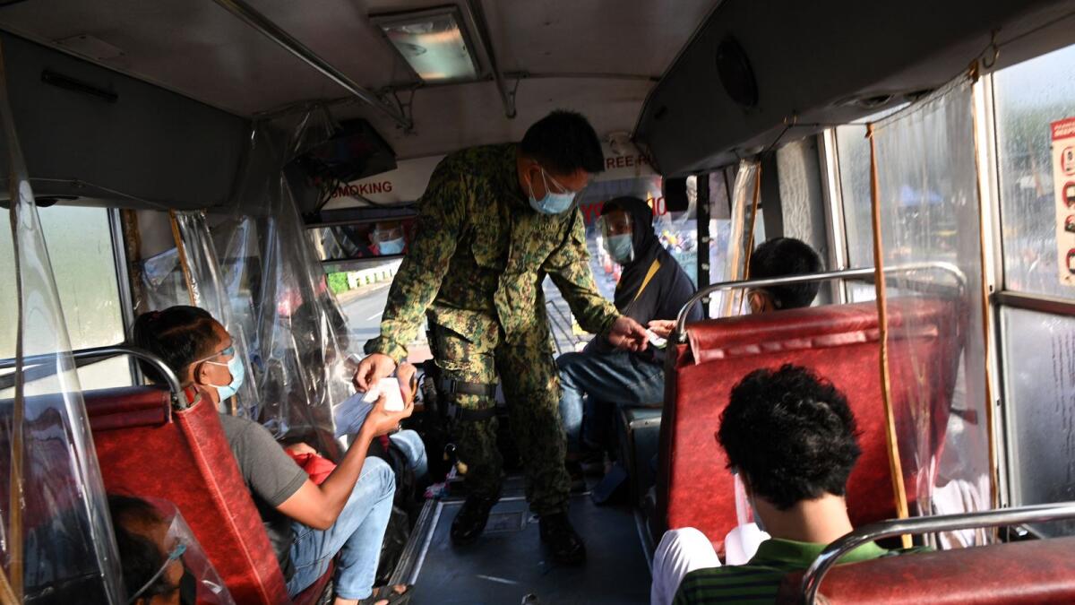 A police officer inspects documents of passengers travelling in a bus at a border checkpoint in suburban Manila. Photo: AFP