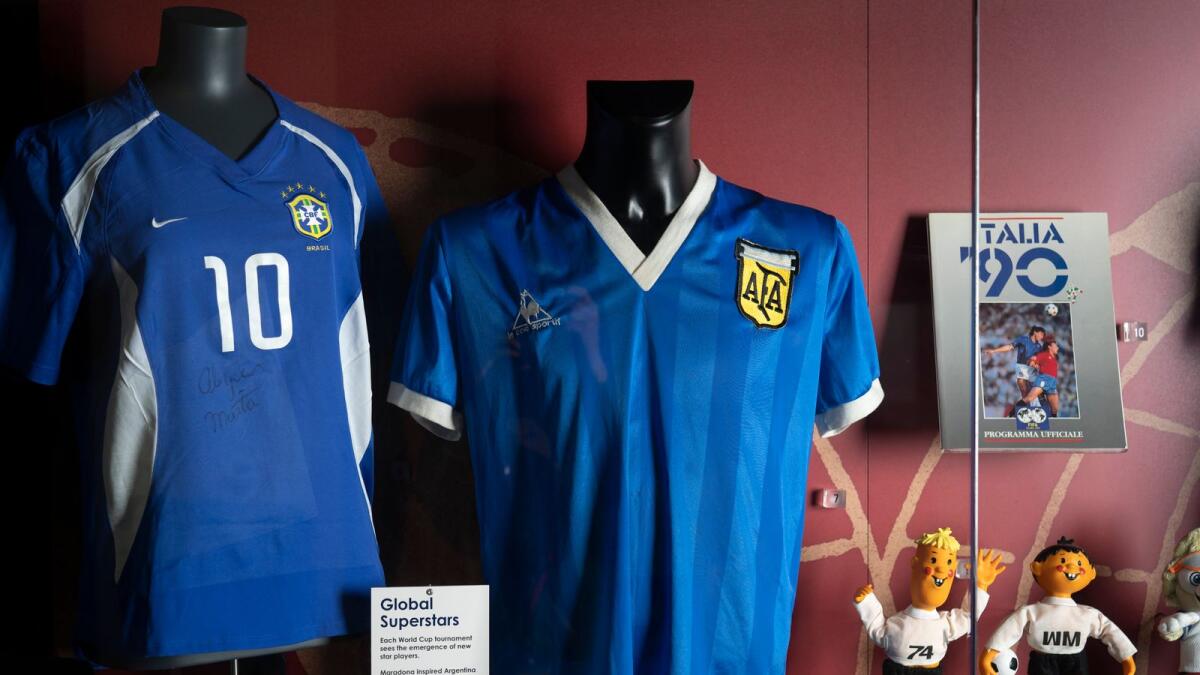 The football shirt (centre), worn by Argentina legend Diego Maradona in the 1986 World Cup quarterfinal against England, is displayed at the National Football Museum in Manchester, England. (AP)