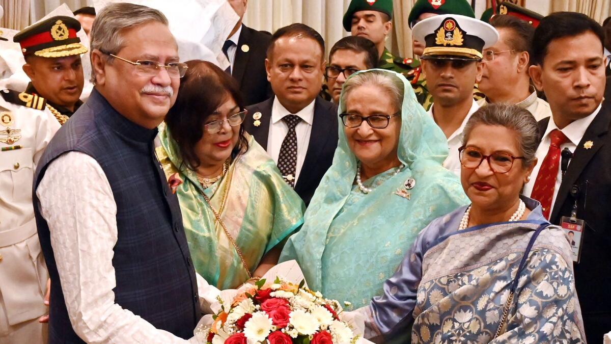 Bangladesh's President elect Mohammed Shahabuddin (L) receives floral wreath from Bangladesh's Prime Minister Sheikh Hasina (2R) during an oath taking ceremony at the presidential palace in Dhaka. — AFP