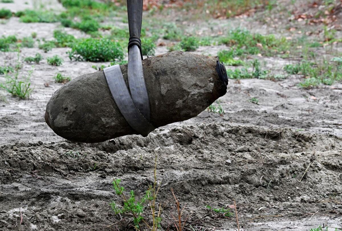 A World War Two bomb is seen being removed a few days after being discovered in the dried-up river Po which suffered from the worst drought in 70 years, in Borgo Virgilio, Italy